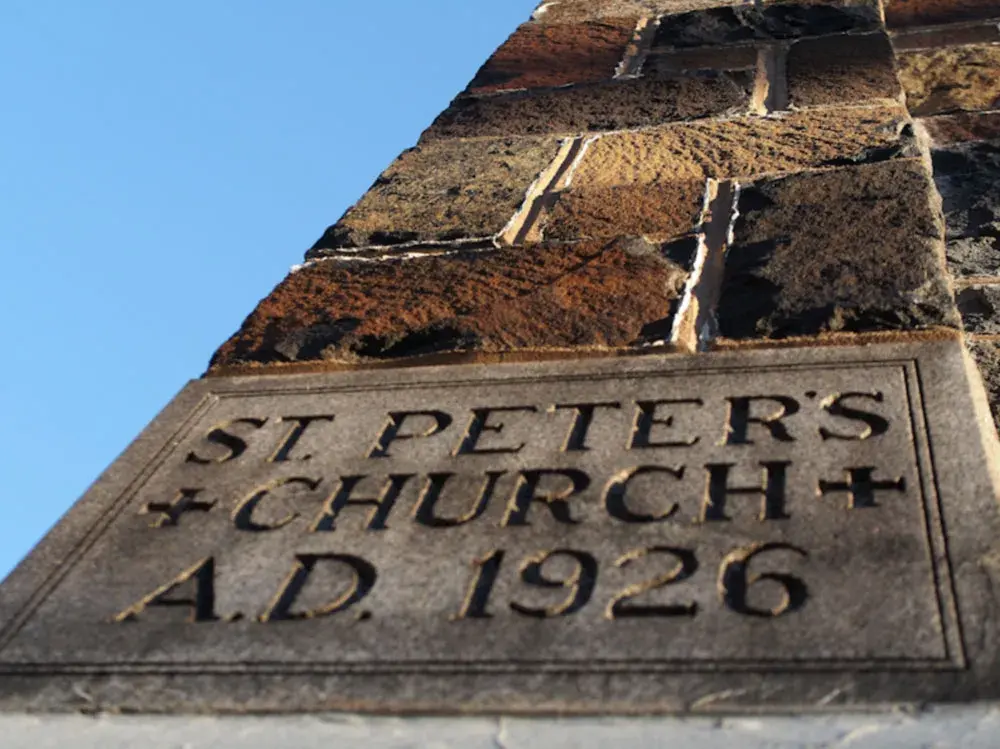Close-up of a stone plaque on a church wall that reads 